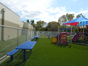 Image of artifical turf, site furnishings and playground equipment at an education center in Florida